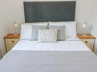 a bedroom with a white bed with two lamps at Langtree in Carnforth