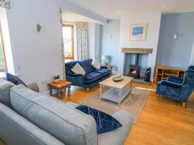 a living room with blue furniture and a fireplace at Langtree in Carnforth