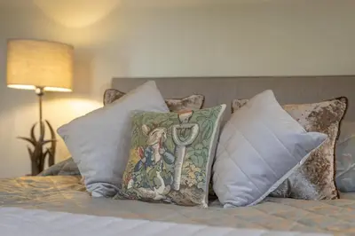 a pile of pillows on a bed in a bedroom at Woodhaven - Luxury 4 bedroom rural retreat with hot tub near to Lake District in Grange Over Sands