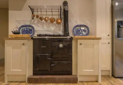 a kitchen with a stove and some blue dishes at Woodhaven - Luxury 4 bedroom rural retreat with hot tub near to Lake District in Grange Over Sands
