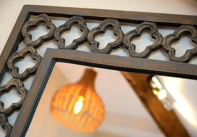 a mirror with an orange vase and a vase at Pippin Lodge Lytham in Lytham St Annes