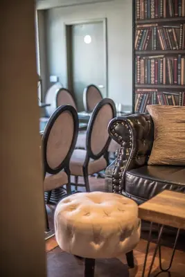 a room with chairs and a table and a stool at N'ista Boutique Rooms Birkdale, Southport in Southport
