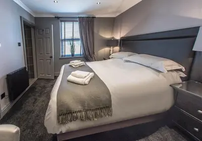 a bedroom with a large bed with two towels on it at N'ista Boutique Rooms Birkdale, Southport in Southport