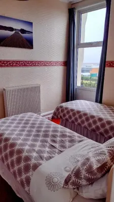 a bedroom with two beds and a window at The Kathrene in Fleetwood