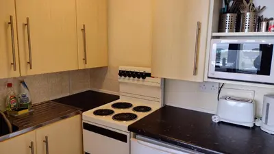 a small kitchen with a stove and a microwave at The Kathrene in Fleetwood