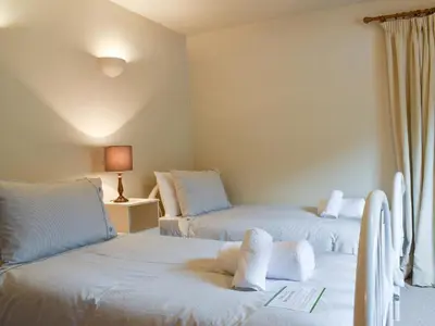 a room with two beds with white sheets at Yew Tree Farm in High Newton