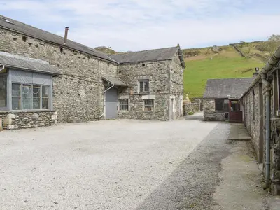 a stone house with a driveway in front of it at Yew Tree Farm in High Newton