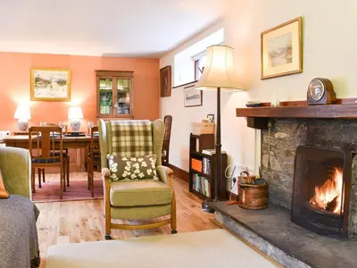 a living room with a fireplace and a dining room at Yew Tree Farm in High Newton