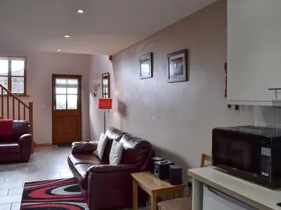 a living room with a couch and a tv at Lakeland View in Scotforth