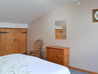 a bedroom with a bed and a dresser and a chair at Lakeland View in Scotforth