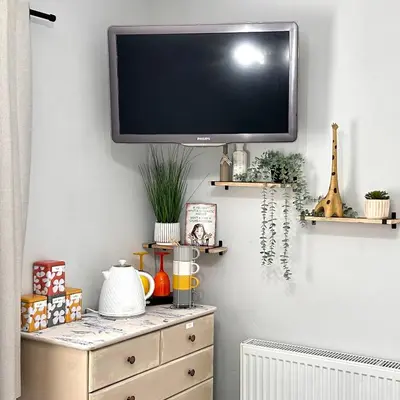 a tv on a wall above a dresser in a room at HomeStay In The Bay By The Beach in Heysham