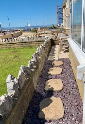 a stone walkway next to a building with a window at HomeStay In The Bay By The Beach in Heysham