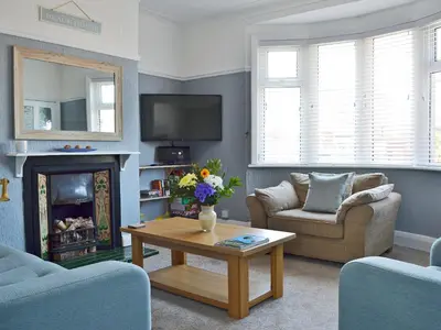 a living room with two chairs and a fireplace at The Beach House in Saint Annes on the Sea