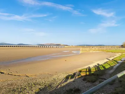 a view of a beach with a bridge in the distance at Underhill Cottage in Arnside