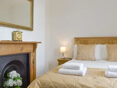 a bedroom with a bed with towels on it at Underhill Cottage in Arnside