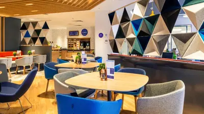a restaurant with blue chairs and tables at Holiday Inn Express - Barrow-in-Furness & South Lakes by IHG in Barrow in Furness