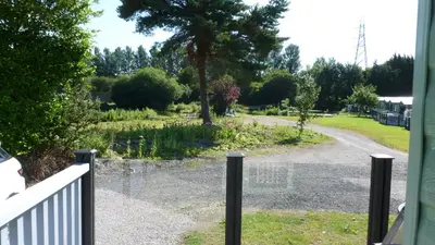 a view of a driveway from a house with a fence at 28 Borwick Lakes in Carnforth