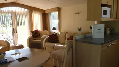 a kitchen and living room with a table and a couch at 28 Borwick Lakes in Carnforth