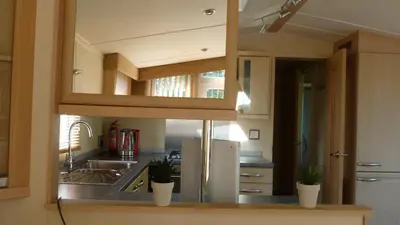 a kitchen with a sink and a refrigerator at 28 Borwick Lakes in Carnforth