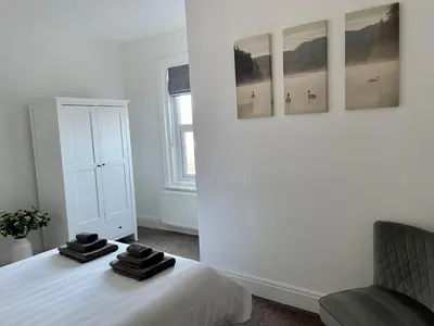 a bedroom with a bed with three pictures on the wall at The Place - Lytham in Lytham St Annes