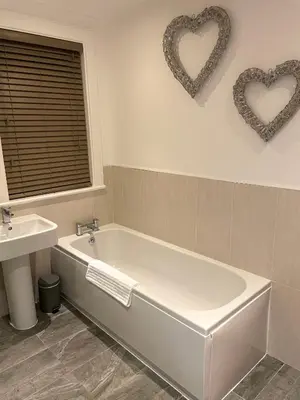 a bathroom with a tub and two hearts on the wall at The Place - Lytham in Lytham St Annes