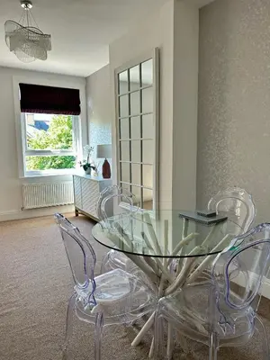 a dining room with a glass table and chairs at The Place - Lytham in Lytham St Annes