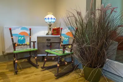 a room with two chairs and a lamp and plants at Hampsfell Cottage, quaint and comfy by the Lake District in Grange Over Sands