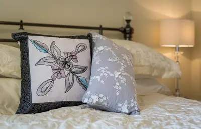 a pillow sitting on top of a bed at Hampsfell Cottage, quaint and comfy by the Lake District in Grange Over Sands