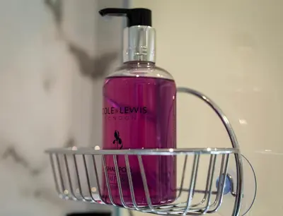 a bottle of pink liquid in a wire basket at Hampsfell Cottage, quaint and comfy by the Lake District in Grange Over Sands