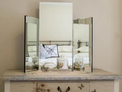 a dressing table with a mirror and a bed at Hampsfell Cottage, quaint and comfy by the Lake District in Grange Over Sands