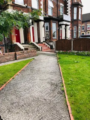 a cobblestone path in front of a house at Castle Lodge Guest House 86-88 Sheil Rd L6 3AF in Liverpool