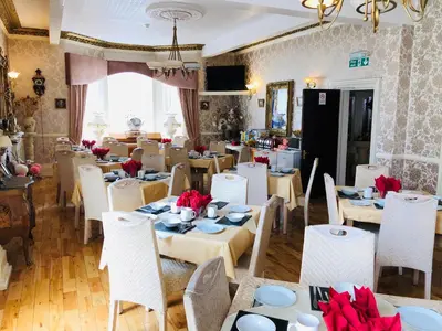 a dining room with tables and white chairs with red bows at Castle Lodge Guest House 86-88 Sheil Rd L6 3AF in Liverpool