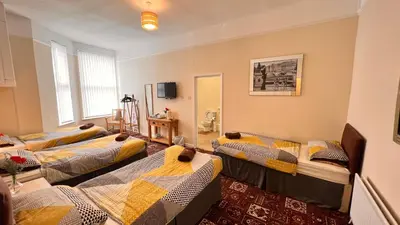 a room with four beds in a room at Castle Lodge Guest House 86-88 Sheil Rd L6 3AF in Liverpool