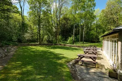 a group of picnic tables in a field of grass at Woodlands Hotel & Pine Lodges in Grange Over Sands