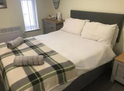 a bedroom with a bed with two towels on it at The Gables Hotel by Cherish Lewis Blackpool in Blackpool