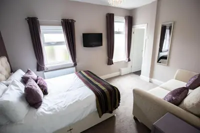 a bedroom with a bed and a couch at The Gables Hotel by Cherish Lewis Blackpool in Blackpool