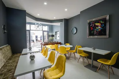 a dining room with yellow chairs and tables at The Gables Hotel by Cherish Lewis Blackpool in Blackpool