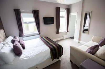 a bedroom with a bed and a couch at The Gables Hotel by Cherish Lewis Blackpool in Blackpool