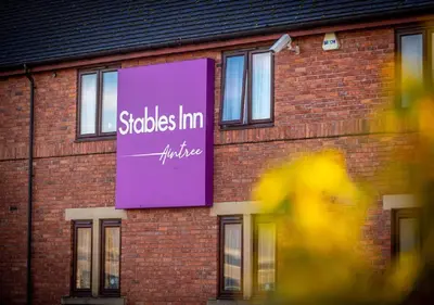a purple sign on the side of a brick building at Stables Inn, Aintree in Liverpool
