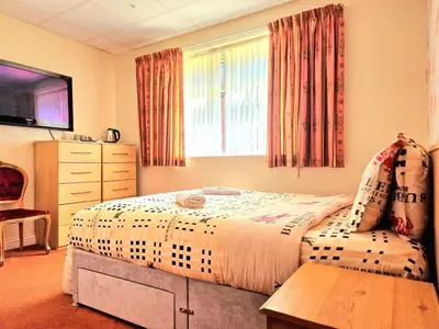 a bedroom with a bed and a dresser and a television at The Albany hotel in Blackpool