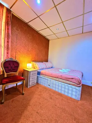 a bedroom with a bed and a chair in it at The Albany hotel in Blackpool