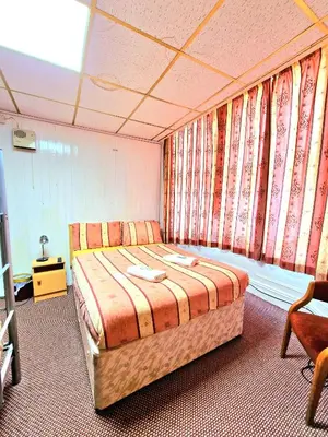 a bedroom with a large bed in a room with curtains at The Albany hotel in Blackpool