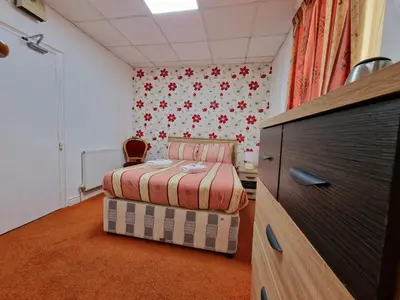 a bedroom with a bed and a dresser in it at The Albany hotel in Blackpool