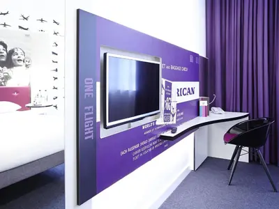 a room with a desk with a tv on a wall at Ibis Styles Liverpool Centre Dale Street - Cavern Quarter in Liverpool