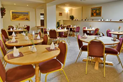 a restaurant with wooden tables and chairs at Stuart hotel in Blackpool