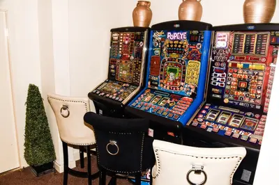 a group of slot machines on a table with chairs at Stuart hotel in Blackpool