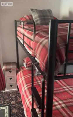 a black bunk bed with a red blanket on it at Sarnia holiday flats in Blackpool