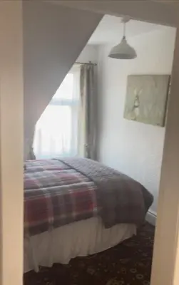a bedroom with a bed and a window at Sarnia holiday flats in Blackpool