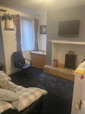 a bedroom with a bed and a chair and a television at Sarnia holiday flats in Blackpool