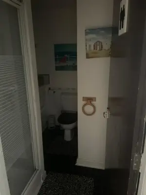 a small bathroom with a toilet and a shower at Sarnia holiday flats in Blackpool